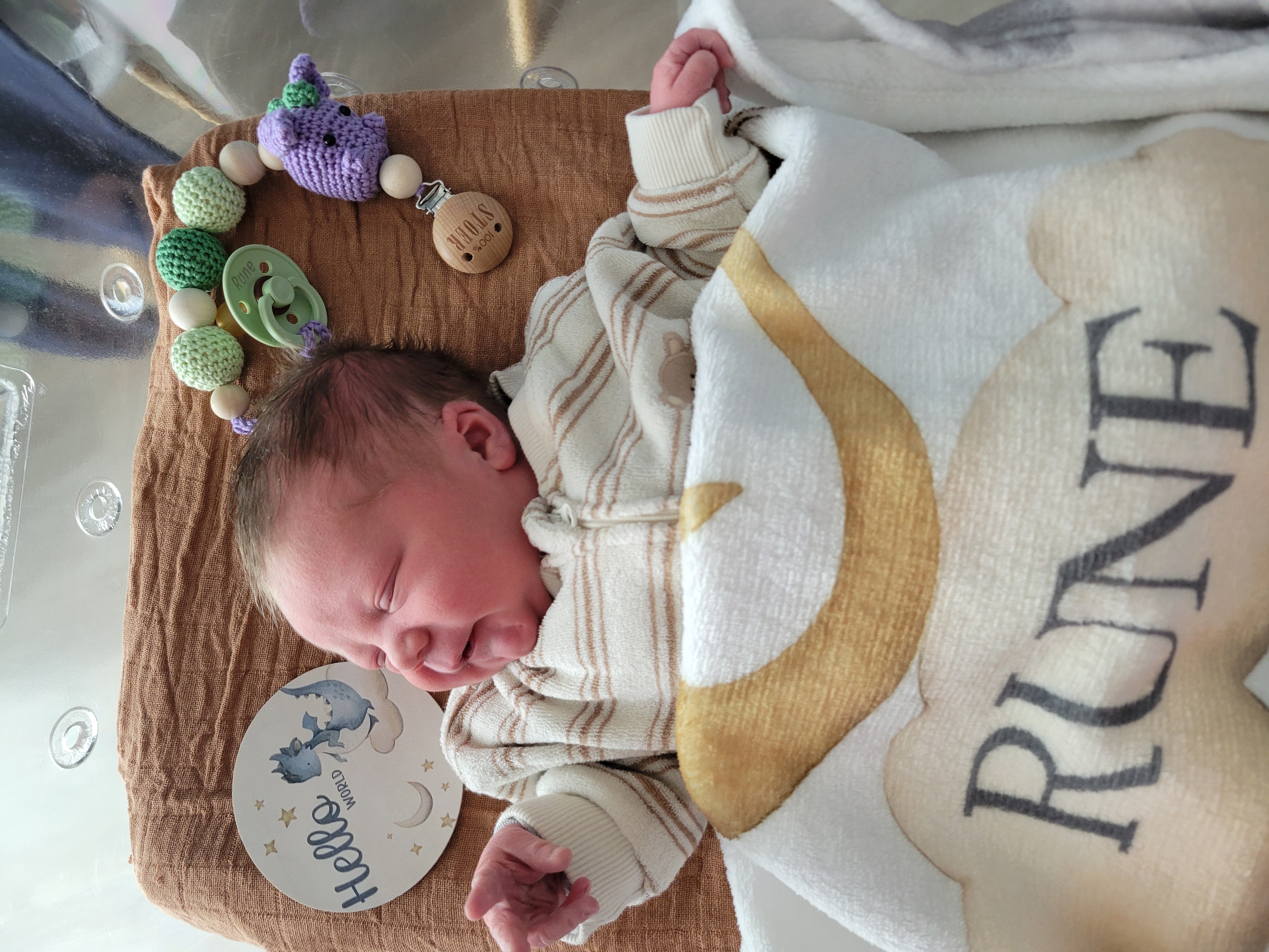 Pasgeboren baby Rune, slapend, met naamdeken en fopspeen